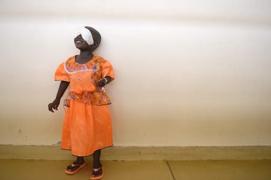 BDI14_011 Young blind girl in orange dress with gauze over her eyes