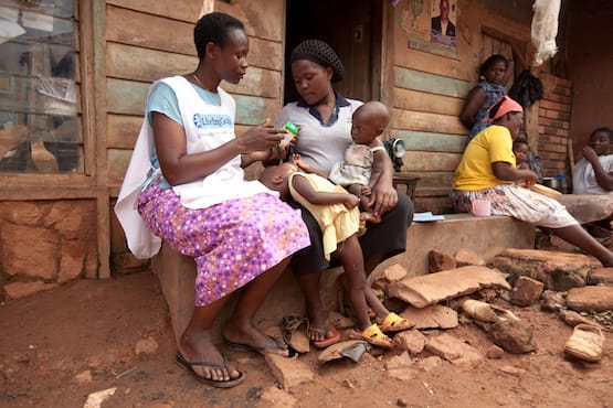 Living Goods community health worker speaking to mother and child