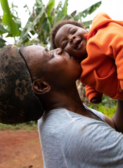 A mother kissing her laughing baby